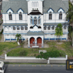 Aerial view of St George's Cathedral and surrounding Georgetown streets, with the Invest Guyana Explains masthead.