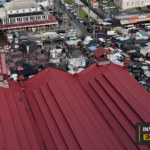 Drone view across the Stabroek Market roof and surrounding Georgetown streets, with the Invest Guyana Explains masthead.