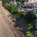 Drone view of coastal properties and a public roadway in Georgetown, with the Invest Guyana Explains masthead.