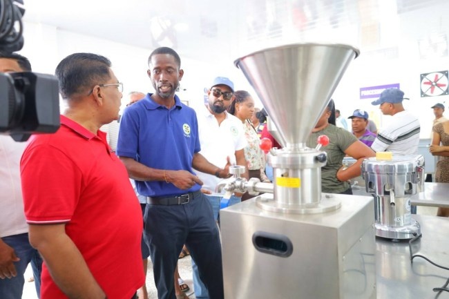 Minister of Agriculture Zulfikar Mustapha views processing equipment at the Canal Number One Polder agro-processing plant.