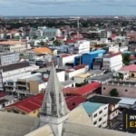 Drone view over Georgetown’s buildings and skyline from Invest Guyana’s own footage.