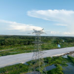 Electrical towers and power lines along a Guyana coastal corridor.