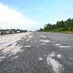 Road surface and construction equipment along the Craig–Land of Canaan highway works, pictured in DPI’s project update.