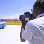 A technician verifies a roadside speed camera in Guyana in August 2026