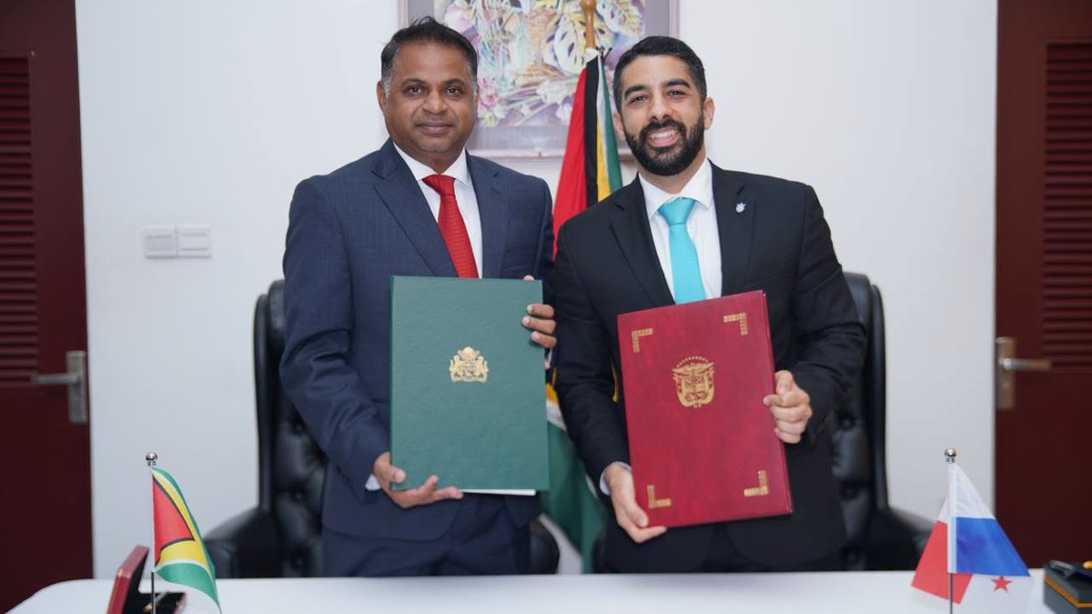 Guyana and Panama officials display signed air-services agreements in Georgetown.
